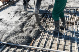 Commercial concrete crew pumping and spreading concrete over a structural rebar grid