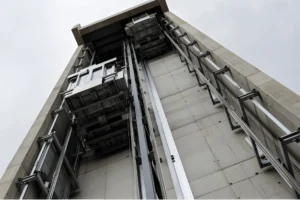 ertical concrete elevator shaft and structural steel guide rail frame under construction for a commercial building.